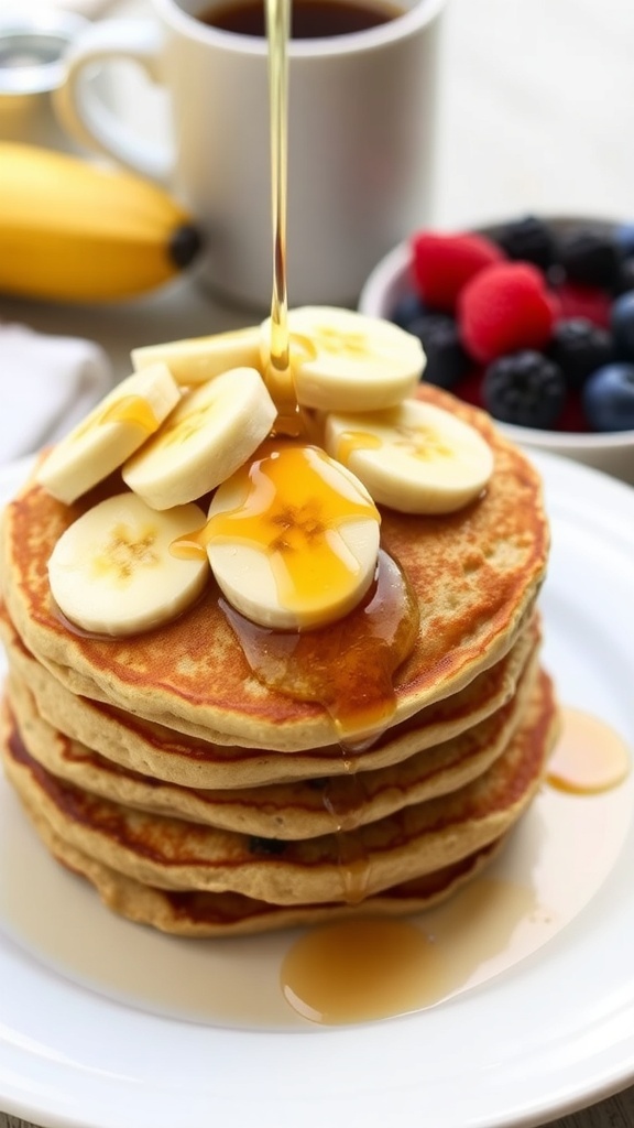 A stack of oat banana pancakes with banana slices and maple syrup on a white plate, accompanied by fresh berries.